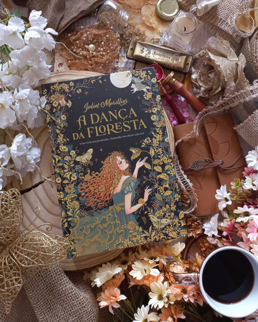 Fotografia em flat lay em cenário da edição do livro A Dança da Floresta, de Juliet Marillier, publicada pela Editora wish no Brasil.
